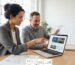 Local web designer and small business owner discussing SEO dashboard in bright studio