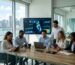 Diverse business team in modern Miami office reviewing local SEO dashboard with Florida map on large monitor