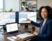 AI consultant at a modern desk with dual monitors displaying local SEO dashboards and maps, pointing to a chart while a laptop shows Google My Business listings in a bright office.