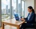 Professional SEO analyst viewing analytics on laptop in bright Miami office with city skyline view