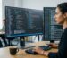Developer working on website configuration on dual monitors in a clean office