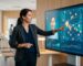 Marketing strategist gesturing toward 3D AI digital twin avatar on large screen with local maps and data streams