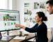 Web designer presenting a custom Shopify ecommerce theme to a colleague on a large monitor in a bright modern office.