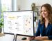 Smiling business owner viewing a Google Business Profile dashboard with star ratings and a map on a desktop monitor in a bright office