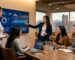 Marketing team collaborating around a large screen with SEO dashboards in a Denver office, city skyline visible through windows.