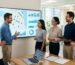 Diverse marketing team in a bright modern office gathered around a large screen showing a map with pins and SEO graphs for local client strategy